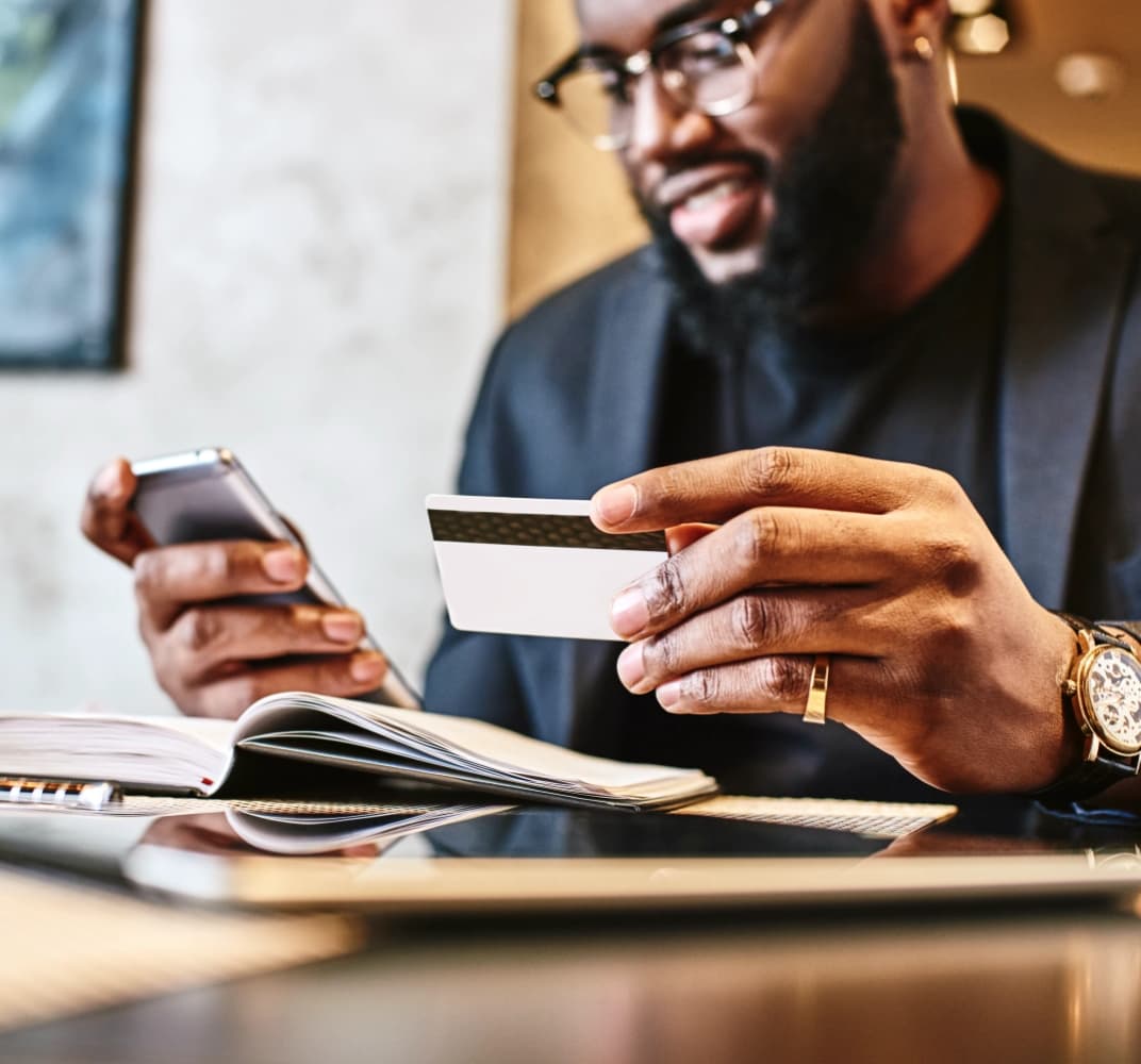 man holding credit card and phone
